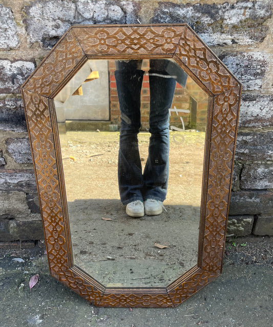 Antique carved octagonal mirror with embossed wooden frame, bevelled glass