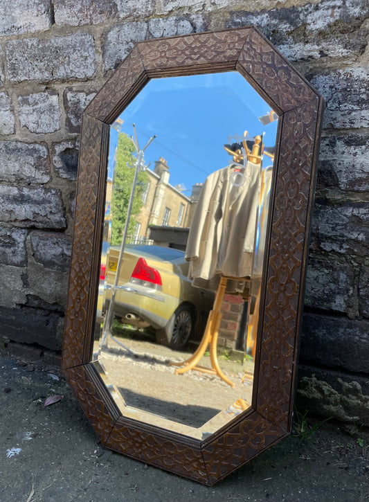 Antique carved octagonal mirror with embossed wooden frame, bevelled glass
