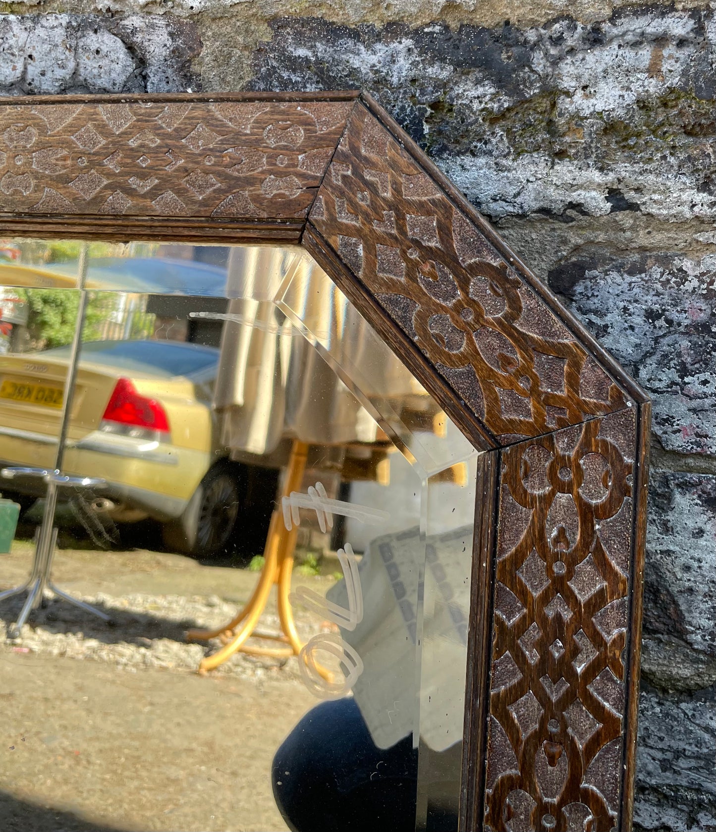 Antique carved octagonal mirror with embossed wooden frame, bevelled glass